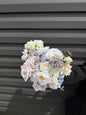 Pastel bridal bouquet with cream roses, garden roses and delicate blue accents. Classic and perfect